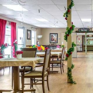 A spacious and well-decorated dining area featuring tables, chairs, and a plant-adorned column.