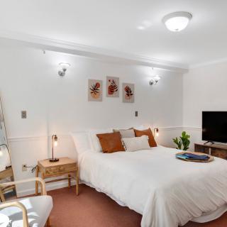 A cozy and modern bedroom with warm lighting and stylish decor.