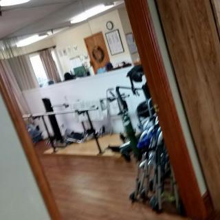 View of an office or lobby area with wheelchairs and furniture through a doorway.