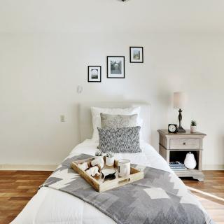 A minimalist bedroom with a single bed and neutral decor.