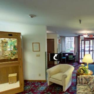 A cozy lobby with seating, a fish tank, and a computer terminal.