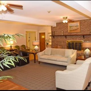 A cozy living room with a brick fireplace, comfortable sofas, and warm lighting.