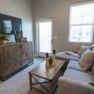 A modern living room with a comfortable sofa, wooden coffee table, and wall-mounted television.