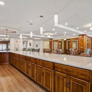 A spacious kitchen with wooden cabinets and ample countertop space, featuring modern lighting and a hardwood floor.
