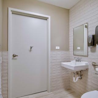 A clean and modern bathroom interior featuring a sink, mirror, and door.