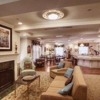 A cozy living room interior with a fireplace, comfortable seating, and elegant lighting.