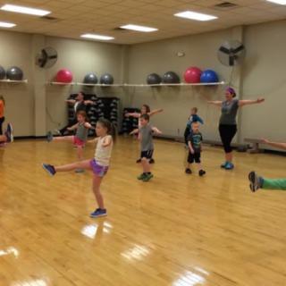 A group of children participating in a fitness class at the gym.