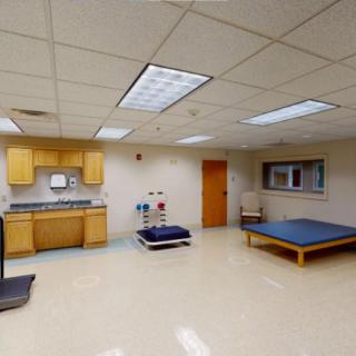 A therapy room equipped for rehabilitation with exercise equipment and medical facilities.