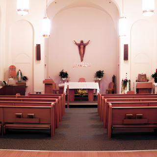 Interior view of a church with an altar and pews.