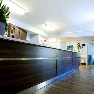 A modern office reception area featuring a sleek counter and indoor plants.