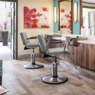 A stylish hair salon interior with chairs and mirrors.