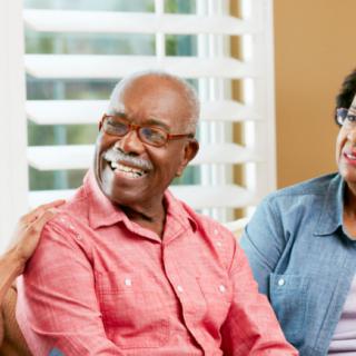 A group of senior adults enjoying a conversation indoors.