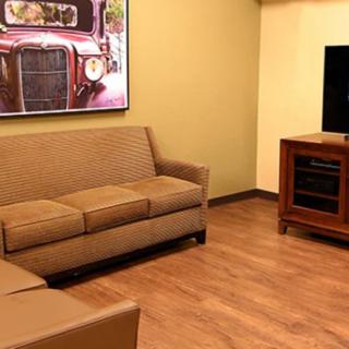 A cozy living room with a sofa, television, and artwork on the wall.