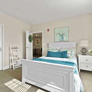 A bright and cozy bedroom with a white bed frame, teal bedding, and stylish decor.
