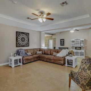 A cozy living room with a large sofa, ceiling fan, and stylish decor.