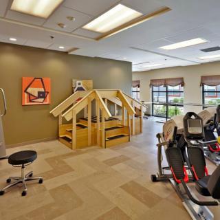 A fitness center with exercise equipment and rehabilitation structures.