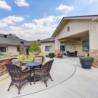 A modern outdoor patio area with wicker furniture and a well-maintained garden.