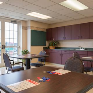 A well-lit interior room featuring tables and chairs, perfect for meetings or activities.