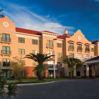 A stylish hotel building with a clear sky and palm trees.