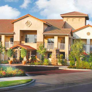 A modern residential building with stylish architecture and landscaped surroundings on a sunny day.