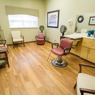 A cozy hair salon with barber chairs and a wooden floor.