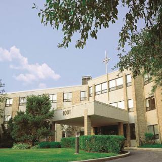 An exterior view of a modern educational building surrounded by greenery.