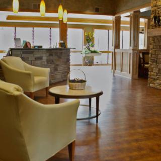 A cozy lobby with modern decor, featuring comfortable seating and a stone fireplace.
