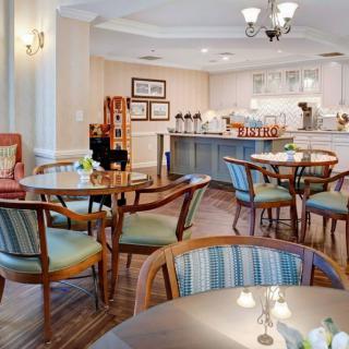 A cozy dining area with tables and chairs, featuring a warm interior design.