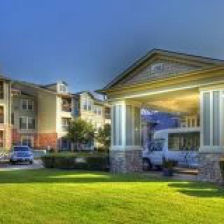 A residential building with a well-maintained lawn during the evening.