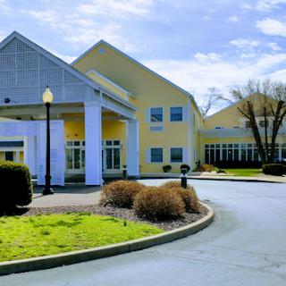 A view of a modern building with landscaped grounds and a clear blue sky.