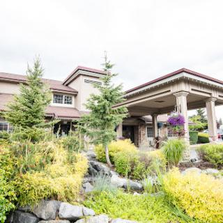 A beautiful modern house surrounded by lush landscaping and vibrant flora.