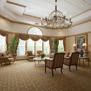 Elegant lobby with a large chandelier, comfortable seating, and large windows.