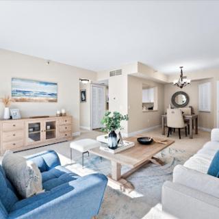 A beautifully designed modern living room featuring a cozy blue and white color scheme, complemented by natural wood furniture and elegant decor.