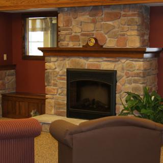 A cozy living room featuring a stone fireplace and comfortable seating, perfect for relaxation.