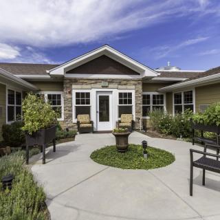 A well-maintained courtyard with outdoor seating and landscaping in front of a modern building.