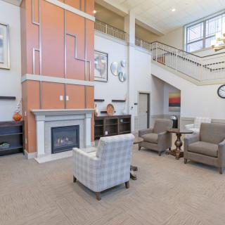 A modern living room with a fireplace, comfortable seating, and a staircase.