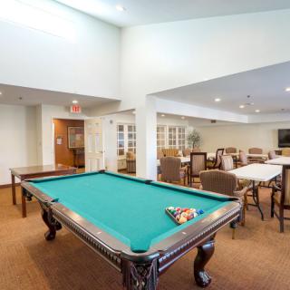 A recreational room featuring a pool table and seating area.
