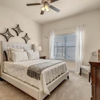 A modern bedroom with elegant decor and ample natural light.