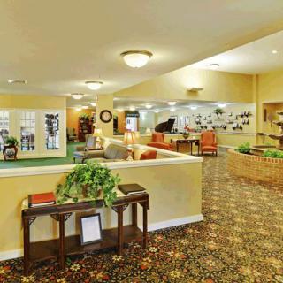 A spacious lobby interior with comfortable seating, decorative plants, and warm lighting.