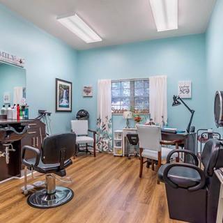 A cozy hair salon with modern furniture and bright lighting.