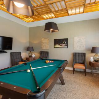 A stylish game room featuring a pool table and comfortable seating.