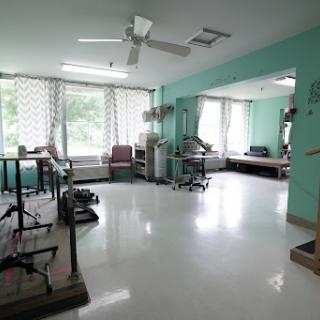 A bright and spacious rehabilitation therapy room equipped with various medical equipment.