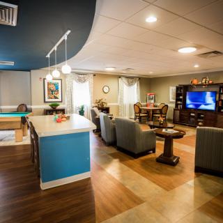 A modern open-plan living and kitchen area with comfortable seating and a television.