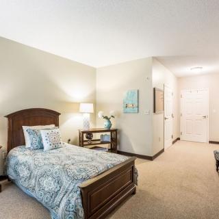 A cozy bedroom with a wooden bed, patterned bedding, and elegant decor.
