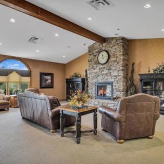A cozy living room with a stone fireplace and comfortable seating.