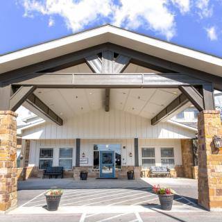 An inviting entrance of a modern building with a covered porch and stone accents.