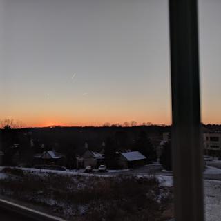A serene winter sunset over a quiet rural landscape.