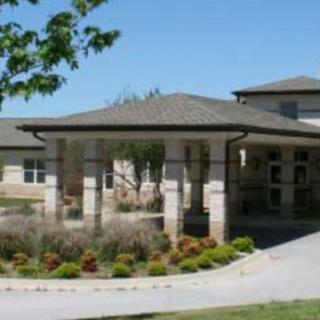 A modern building with a covered entrance and landscaped surroundings.