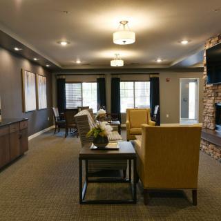A modern living room featuring stylish furniture and a brick accent wall.