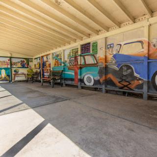 A vibrant mural depicting classic cars in a spacious interior setting.